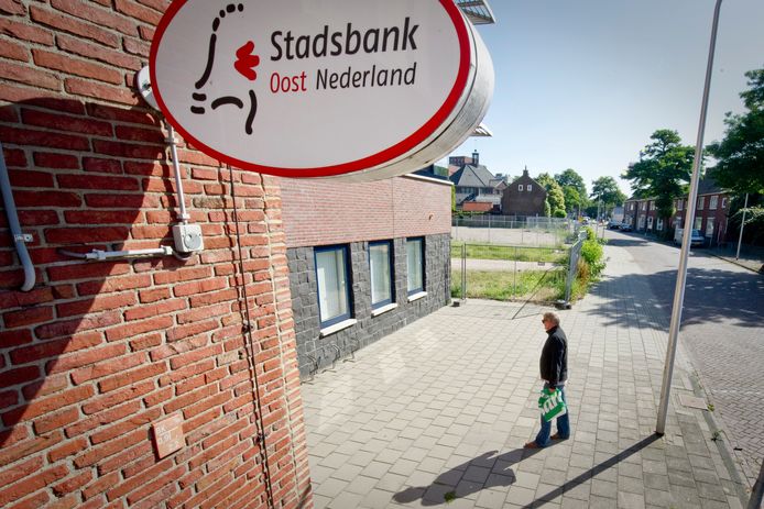 Het pand van de Stasdbank in Enschede, met voor de deur een figurant.
