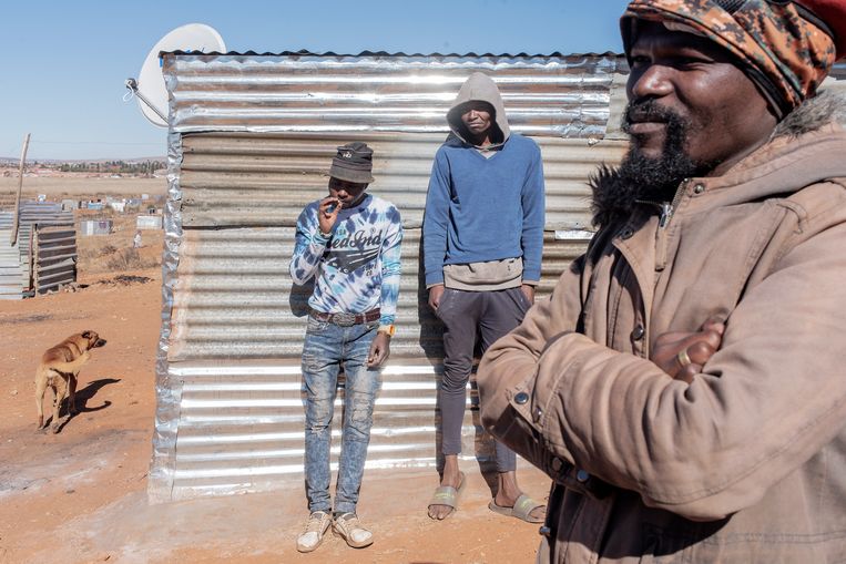 Bongani Ngubane (rechts) in de illegale nederzetting die hij oprichtte bij Johannesburg.  Beeld Luca Sola