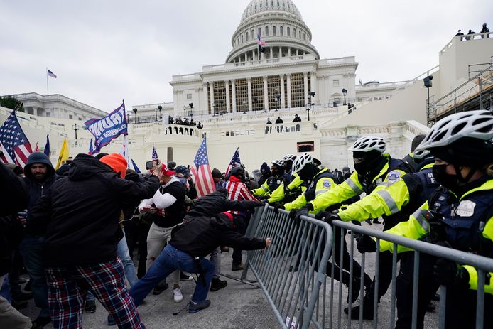 Trump-aanhangers proberen door de barricades van de politie te breken.