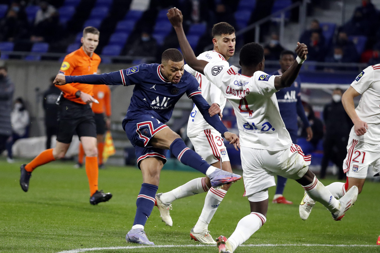 PSG-vedette Kylian Mbappé trapt naar het doel van Lyon tijdens de competitietopper van zondag in Frankrijk. Zeker vijf Parijzenaars zijn onlangs positief getest. Beeld Photo News