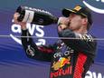 Max Verstappen neemt een teug van de champagne op het podium.