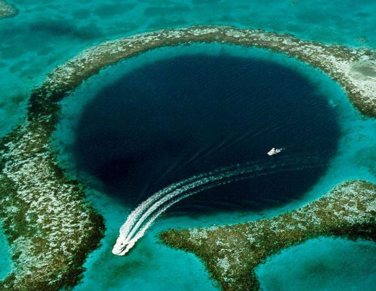 Het 'Great Blue Hole' voor de kust van Belize, de bekendste onderwatergrot in het koraalrif. Beeld US Geological Survey (USGS)