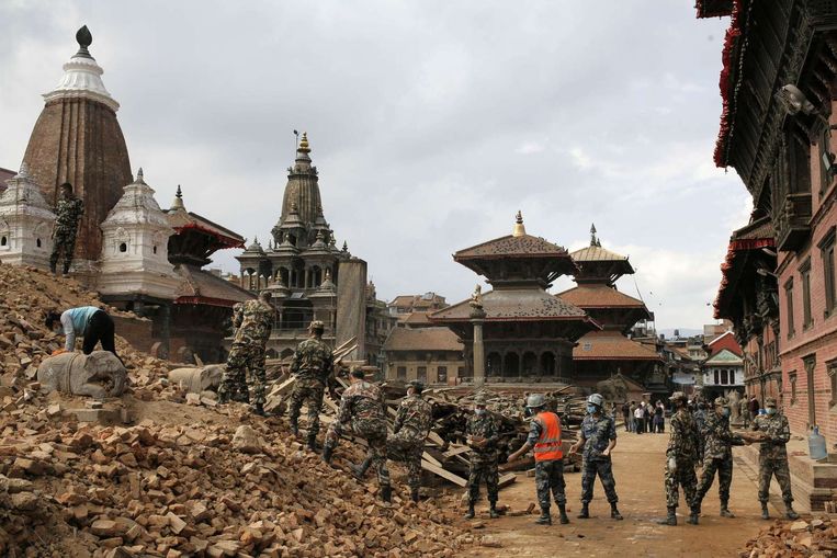 De Nepalese politie en het leger ruimen brokstukken van het Durbarplein, dat op de Werelderfgoedlijst staat. Beeld afp