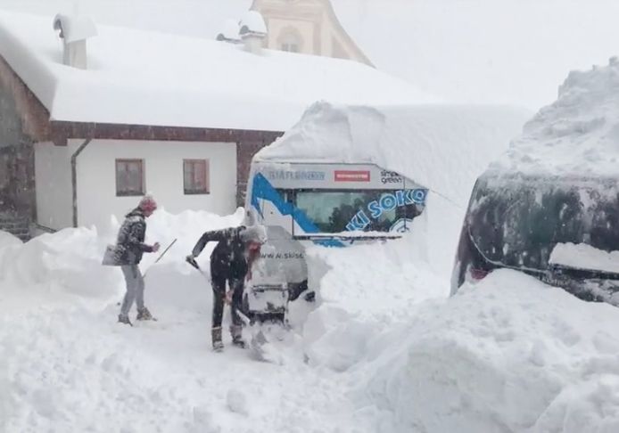 Mensen graven hun voertuig uit in Obertillach, vlakbij de Italiaanse grens in Oostenrijk.