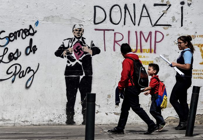 Een muurschildering in Caracas van de Amerikaanse president Trump die een t-shirt met een swastika - het symbool van nazi-Duitsland - onthult.