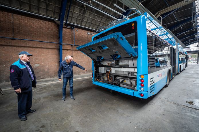 Hans Aldenkamp van Connexxion wijst op de accu in de nieuwe trolley 2.0. Links buschauffeur Jan Lagerweij.