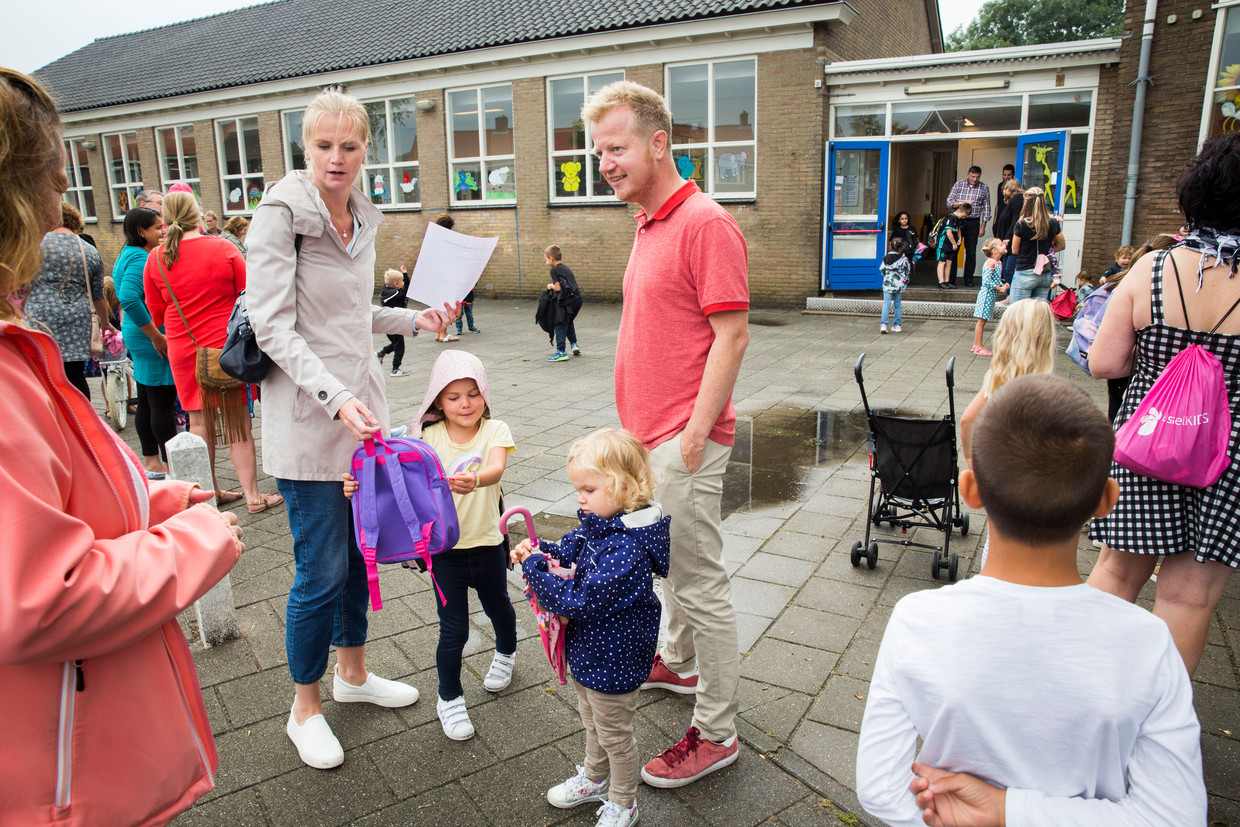 Claudia Haije (lichtblond) haalt haar vierjarige dochter van school in Capelle a/d IJssel. Meester Mark (rechts) en Katinka Meindert (donkerblond) zijn ook mee. Beeld Arie Kievit