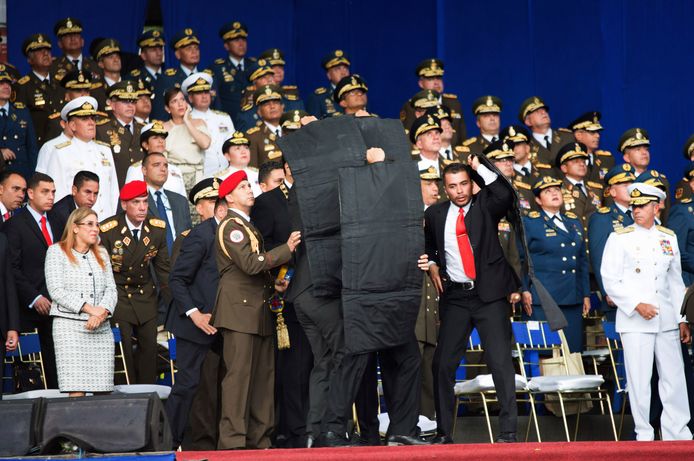 Op andere beelden is te zien hoe Maduro zijn toespraak over de staat van de economie onderbreekt nadat plots een explosie weerklinkt. Na een korte stilte wordt hij omringd door bodyguards die zwarte, waarschijnlijk kogelwerende, schermen omhoog houden.