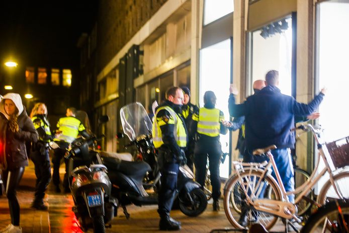 Agenten fouilleren jongeren op het Achterom in het centrum van Dordrecht.