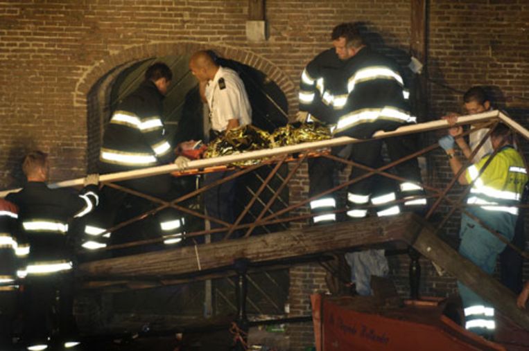 Hulpverleners dragen een slachtoffer weg over de restanten van een brug aan de Utrechtse gracht die zondagavond instortte. Er zijn zeven zwaargewonden gevallen, van wie er drie in kritieke toestand verkeren. (ANP) Beeld 