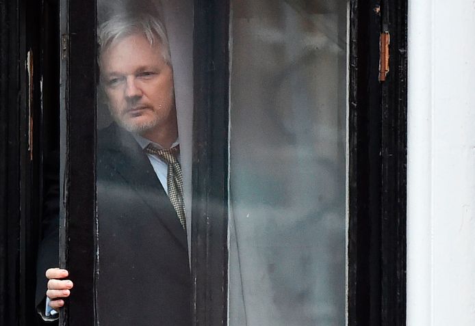 Klokkenluider Julian Assange komt aan het raam piepen in de Ecuadoriaanse ambassade in Londen. Hij woont er nu al vijf jaar.