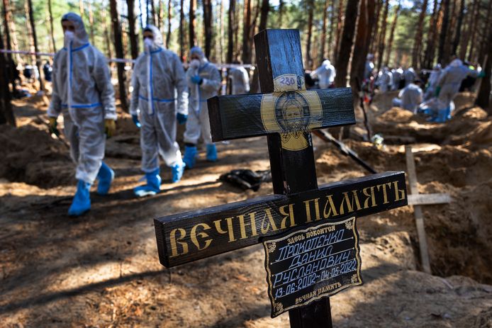 Reddingswerkers en forensische politieagenten graven lichamen op aan een ontdekt massagraf in Izjoem, Oekraïne. De lichamen worden onderzocht op mogelijke oorlogsmisdaden. Beeld van september.