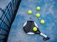 Een padelracket met ballen.