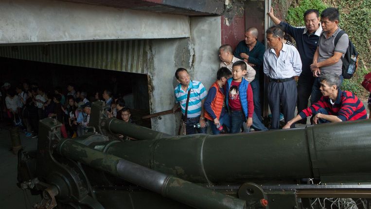 Toeristen bekijken een oud kanon in een verlaten militaire stelling op het eilandje Jinmen, dat hoort bij Taiwan. Veel bezoekers komen van het Chinese vasteland. Beeld WassinkLundgren
