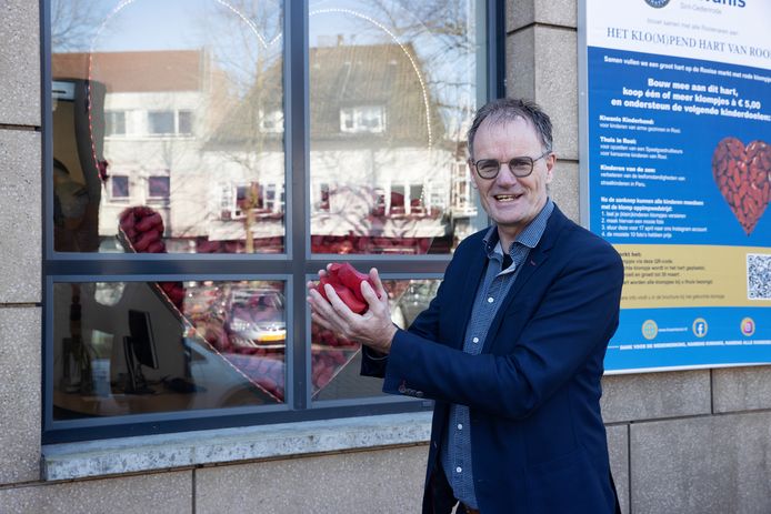 Voorzitter van Kiwanis Rooi Mario Lamers, met een boel rode klompjes in zijn handen.