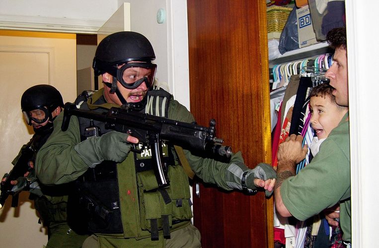 April 2000: de jonge Elián, die zich vasthoudt aan Donato Dalrymple (r), wordt weggehaald bij zijn familie in Miami. De beelden leidden tot woedende reacties in het Republikeinse kamp. Beeld AFP