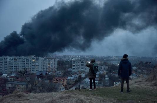 Mensen kijken naar de dikke rookwolken die opstijgen na een raketaanval op Lviv.