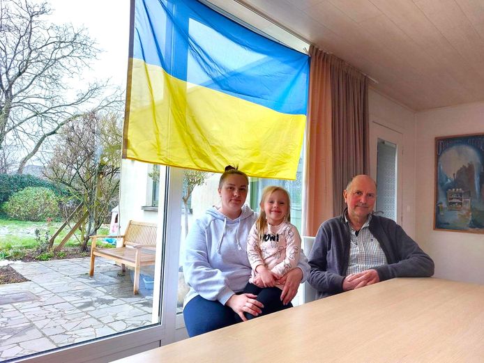Anna, Milana en Hugo in het huis waar ze samen negen maanden woonden en de Oekraïense vlag een prominente plek krijgt.