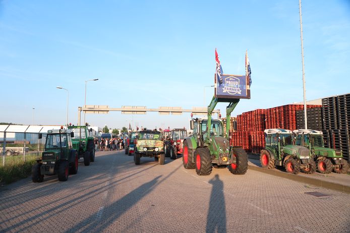 Boeren staan over de hele breedte van de weg bij het distributiecentrum van de Albert Heijn in Geldermalsen. Ze zorgen ervoor dat vrachtwagens de loods niet kunnen verlaten.