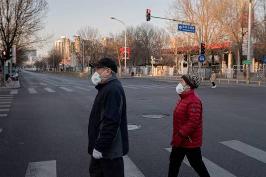 Een koppel in een bijna lege straat in Peking. Gisteren had de PBOC al beloofd om de geldmarkten stabiel te houden met openmarktpolitiek, beleningsfaciliteiten en andere maatregelen.