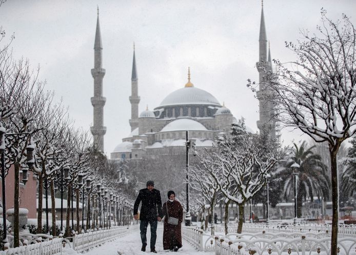Mensen lopen voor de Blauwe Moskee tijdens een besneeuwde dag in Istanbul.
