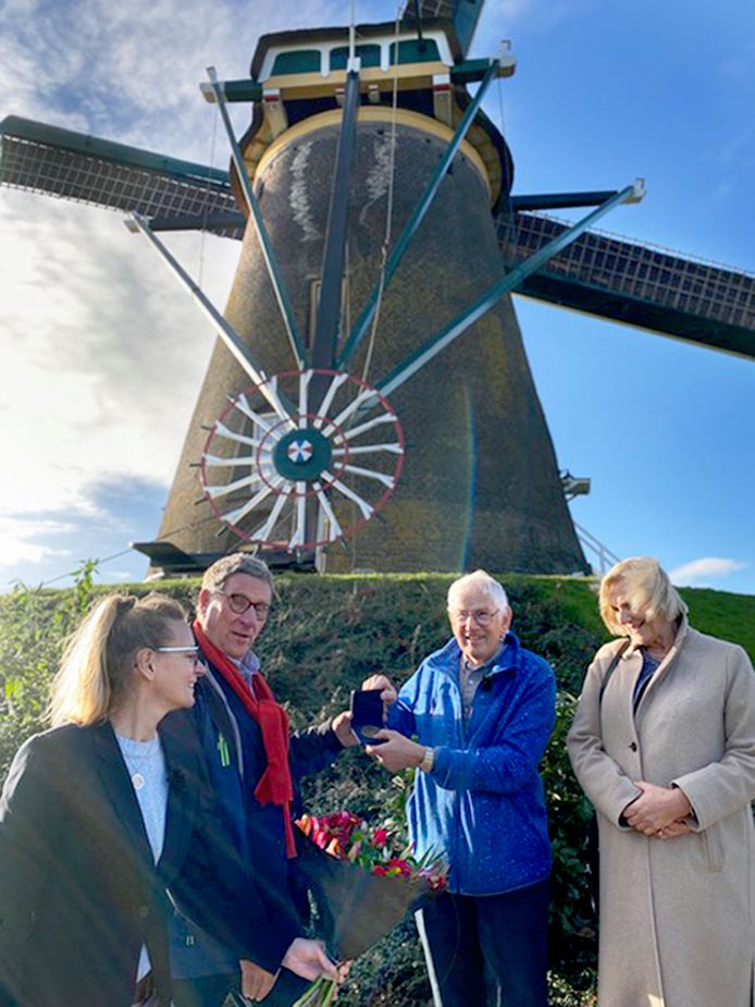 Wim Bos (in het midden, rechts) heeft een onderscheiding gekregen, omdat hij zich jarenlang inzette voor behoud van molens.