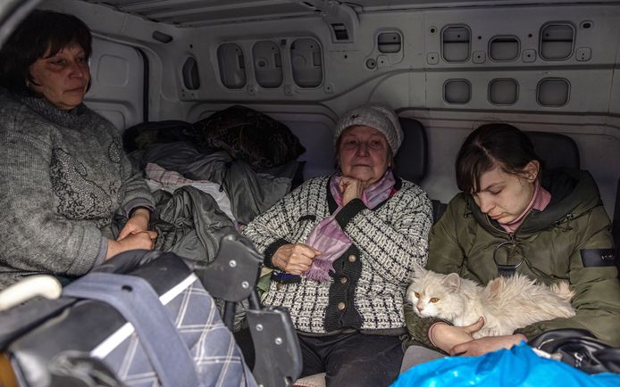 Enkele vluchtelingen uit Marioepol arriveren achteraan in een bestelwagen in Zaporizja.