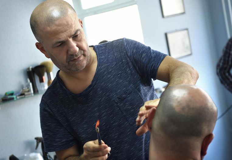 Aslan Isik brandt overtollig oorhaar weg Beeld Marcel van den Bergh