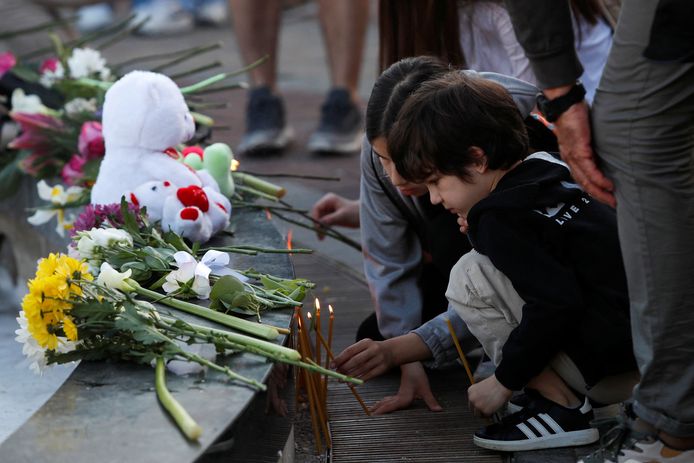 Kinderen branden kaarsjes als eerbetoon aan de slachtoffers van de schietpartij in een Servische school op 3 mei 2023.