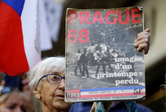 Een betoger houdt een magazine over de inval in Tsjechoslovakije omhoog tijdens de ceremonie.