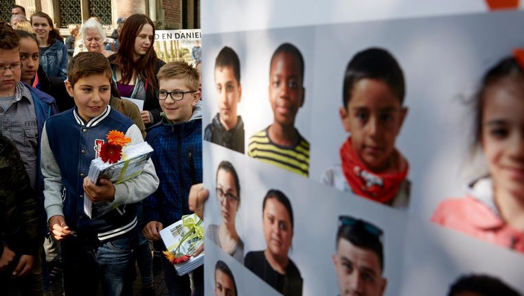 Kinderen overhandigen het fotoboekje Ik Blijf Hier aan Kamerleden. Het boekje is een oproep tot verblijfsrecht voor kinderen die al meer dan vijf jaar zonder verblijfsvergunning in Nederland wonen. Beeld anp
