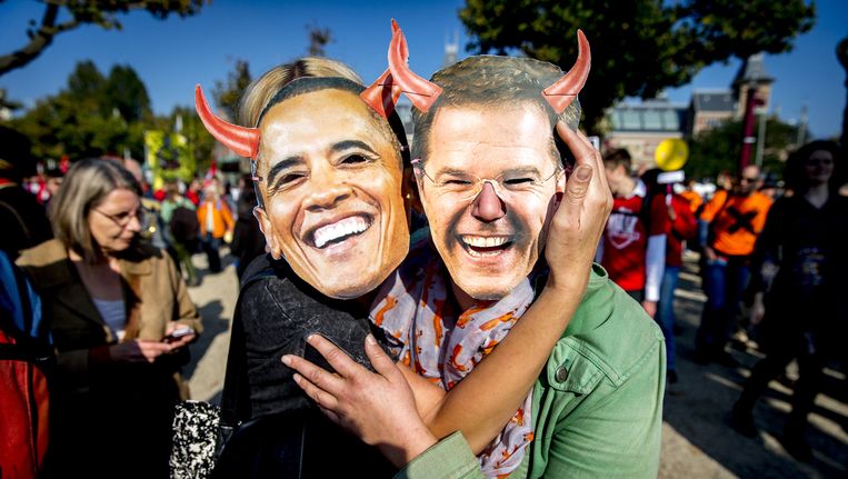 Deelnemers met maskers van Premier Rutte en president Obama tijdens een grote demonstratie tegen het omstreden handelsverdrag TTIP. Beeld anp