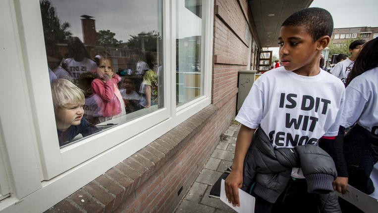 Leerlingen van een Amsterdamse basisschool in witte T-shirts met de provocerende tekst: 'Is dit wit genoeg voor u?', gaan langs de deuren om leerlingen te werven. Beeld anp