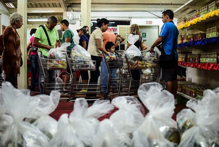 Mensen in de rij om voedselpaketten te bemachtigen, die door de Venezolaanse overheid worden uitgedeeld.  Beeld AFP