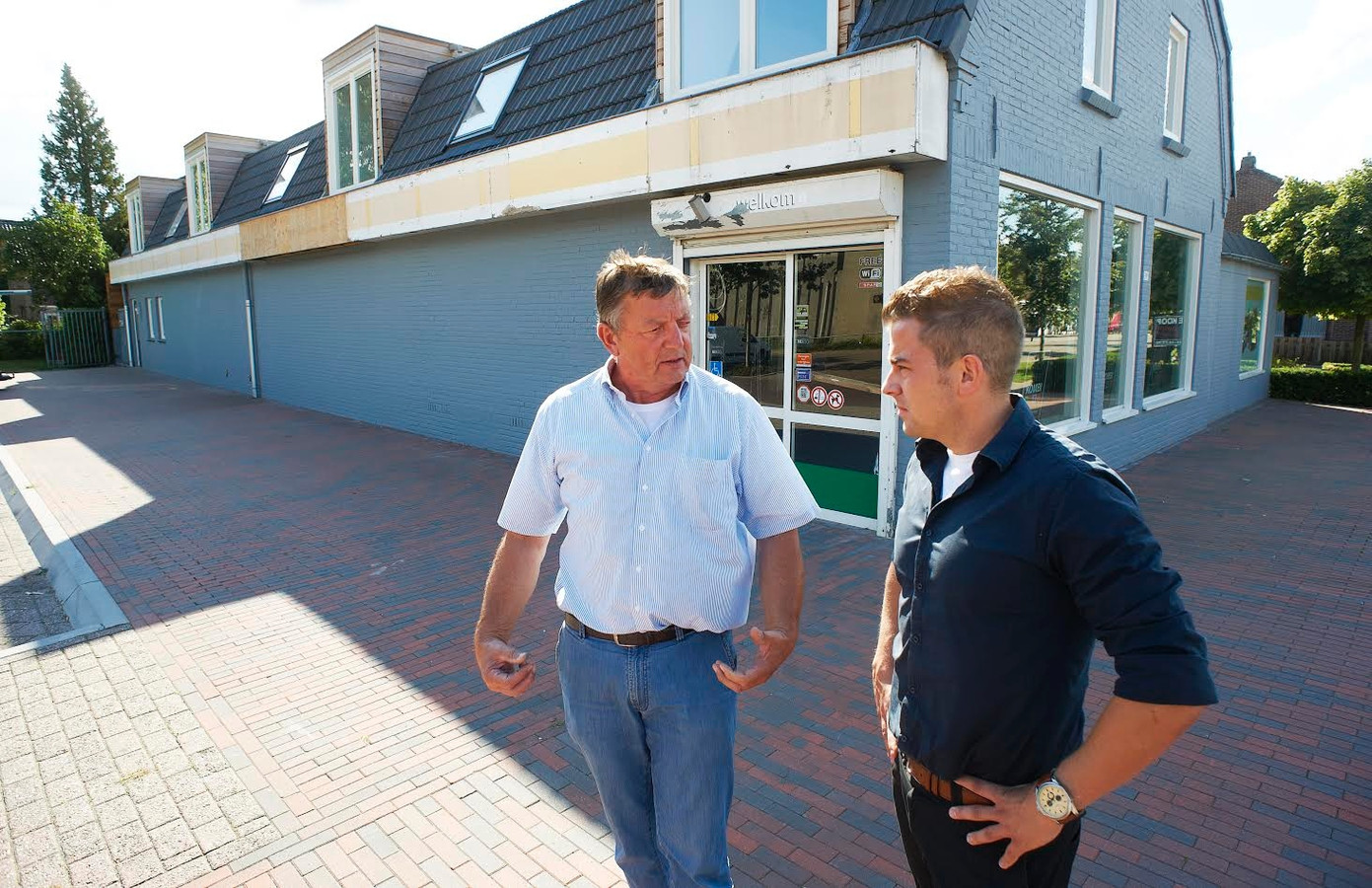Fons Braks en Ton van Buel (r) voor het pand waarin volgende maand een CoopCompact opent.