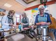 Voedingsdeskundige Judith Bukman (midden) geeft instructies in de keuken en helpt zelf ook een handje mee. Rechts staat Joke Arkesteijn.