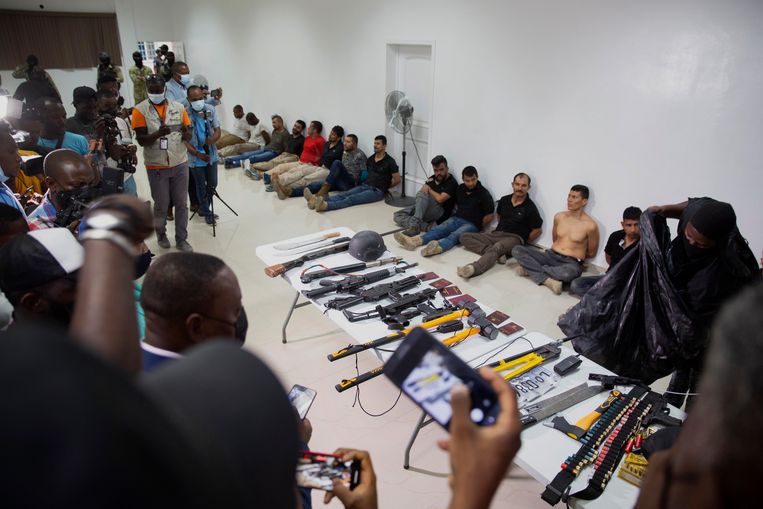 Tijdens een persconferentie op het hoofdbureau van de nationale politie donderdagavond in de hoofdstad Port-au-Prince werden de zeventien arrestanten getoond, evenals een hoeveelheid in beslag genomen wapens van de mogelijke daders van de moord op de Haïtiaanse president Jovenel Moïse. Beeld AP