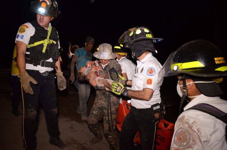 Een vrijwillige brandweerman redt een kind. Beeld AFP