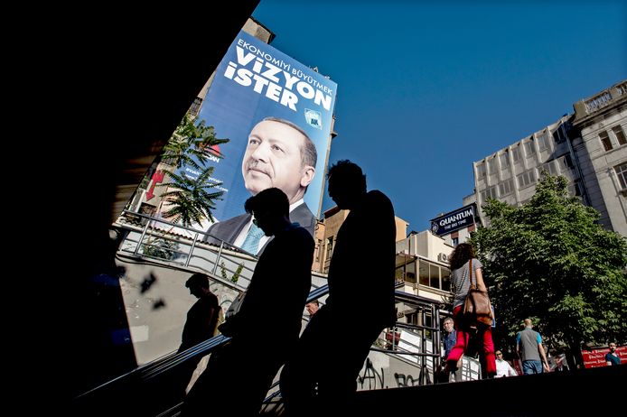 Publiek loopt in Istanboel langs een verkiezingsposter van Recep Tayyip Erdogan.