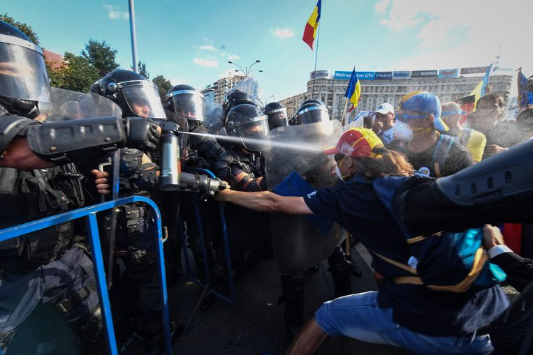 Roemeense politie vechten met demonstranten en spuiten traangas tijdens een antiregeringsprotest in Boekarest. Beeld AFP