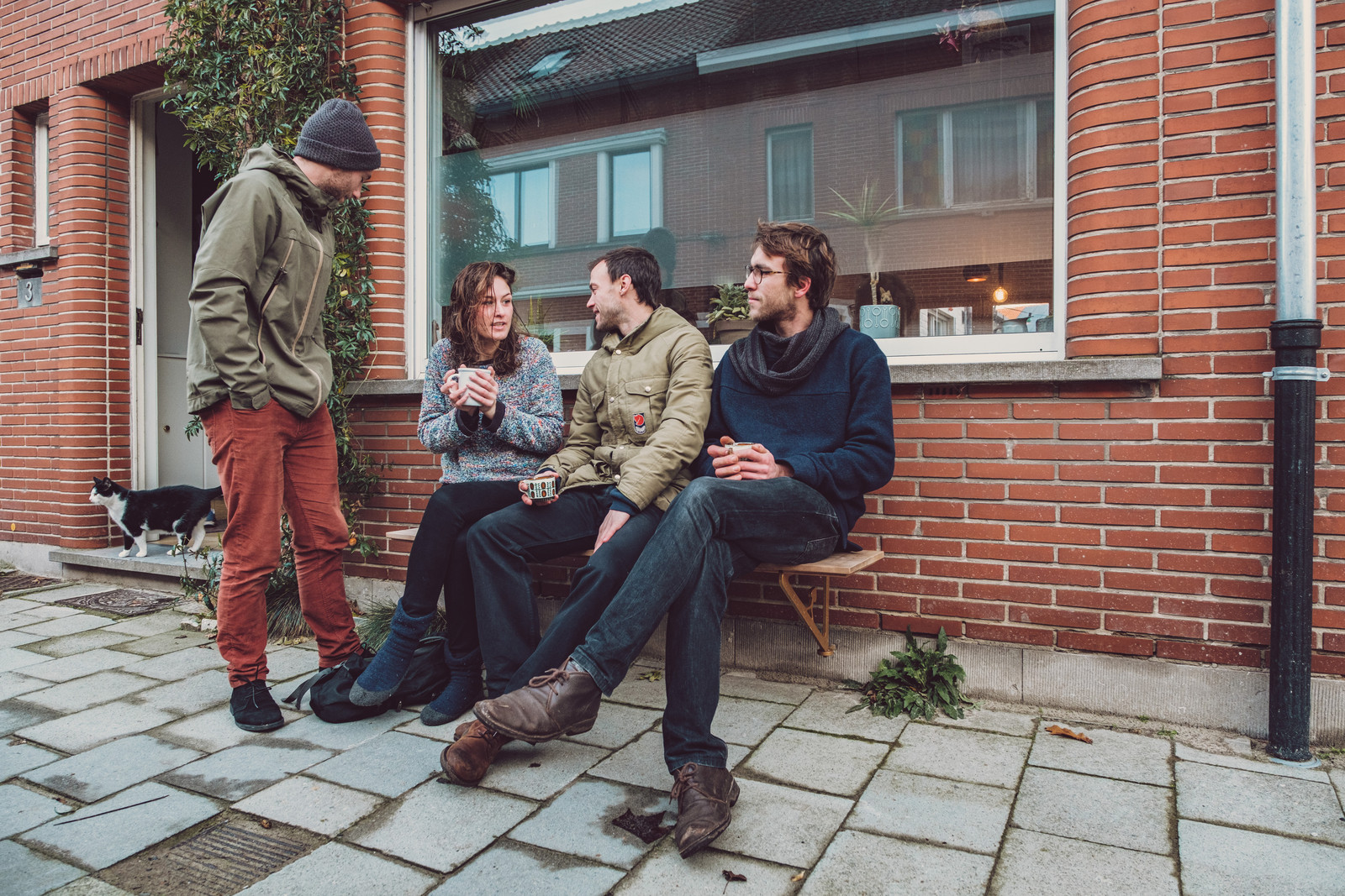 Jesse, Wiske, Anton en Simon op een gevelbank in de Drapierstraat in Mariakerke (Gent). “We creëren opnieuw een klein, gezellig plekje”, zegt Anton Christiaens, een van de bezielers van het bedrijfje Gevelbank. Beeld Wouter Van Vooren