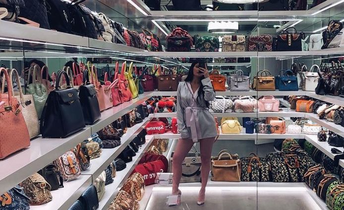 Kylie Jenner tussen al haar handtassen.