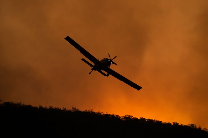 Een blusvliegtuigje stort brandvertragend materiaal uit over de ‘Orroral Valley Fire’ in Namadgi National Park bij Canberra.