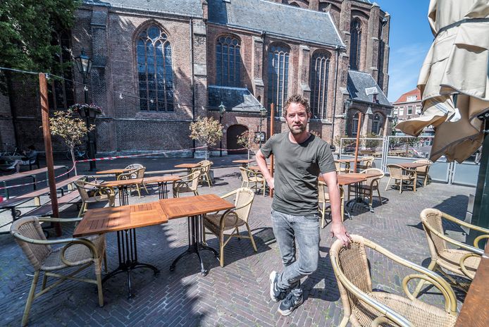 Horeca Delft-voorzitter Jon Cornelese op het aangepaste terras van zijn café de Oude Jan. ,,Iedereen wordt naar een 'geschikte' tafel verwezen."