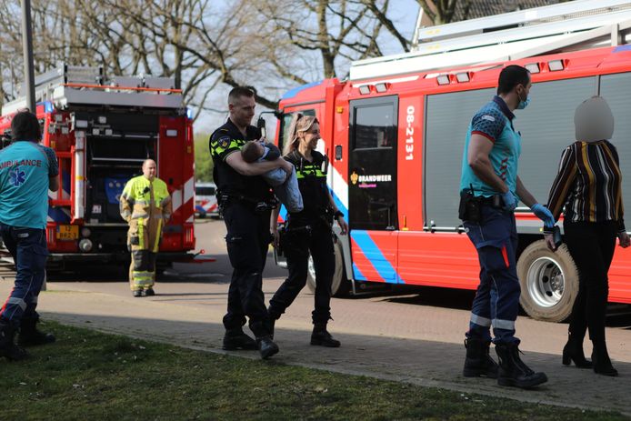 Een agent met de baby in zijn armen na de brand in Nijmegen.