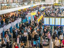 Brandweer deelt water uit aan wachtende mensen op druk Schiphol