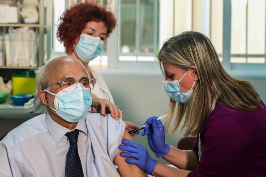 Een medewerker van het ziekenhuis in het Griekse Thessaloniki krijgt het coronavaccin toegediend. 