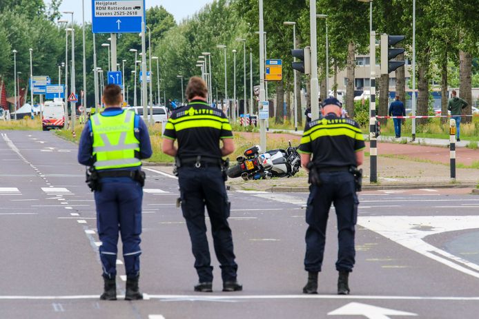 Drie agenten bewaken de weg waar het dodelijke ongeval met hun collega is gebeurd.