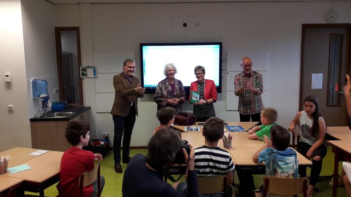 Burgemeester Miranda de Vries heeft zojuist op basisschool De Springplank het boekje gekregen uit handen van schrijfster Ine van den Hoven.