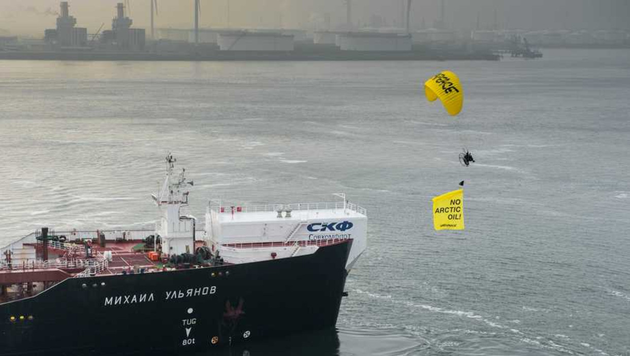 De Rainbow Warrior van Greenpeace vaart langs de Russische olietanker Michail Oeljanov (achtergrond), gevuld met de omstreden Noordpoololie, in de Maasvlakte Olie Terminal. Beeld anp